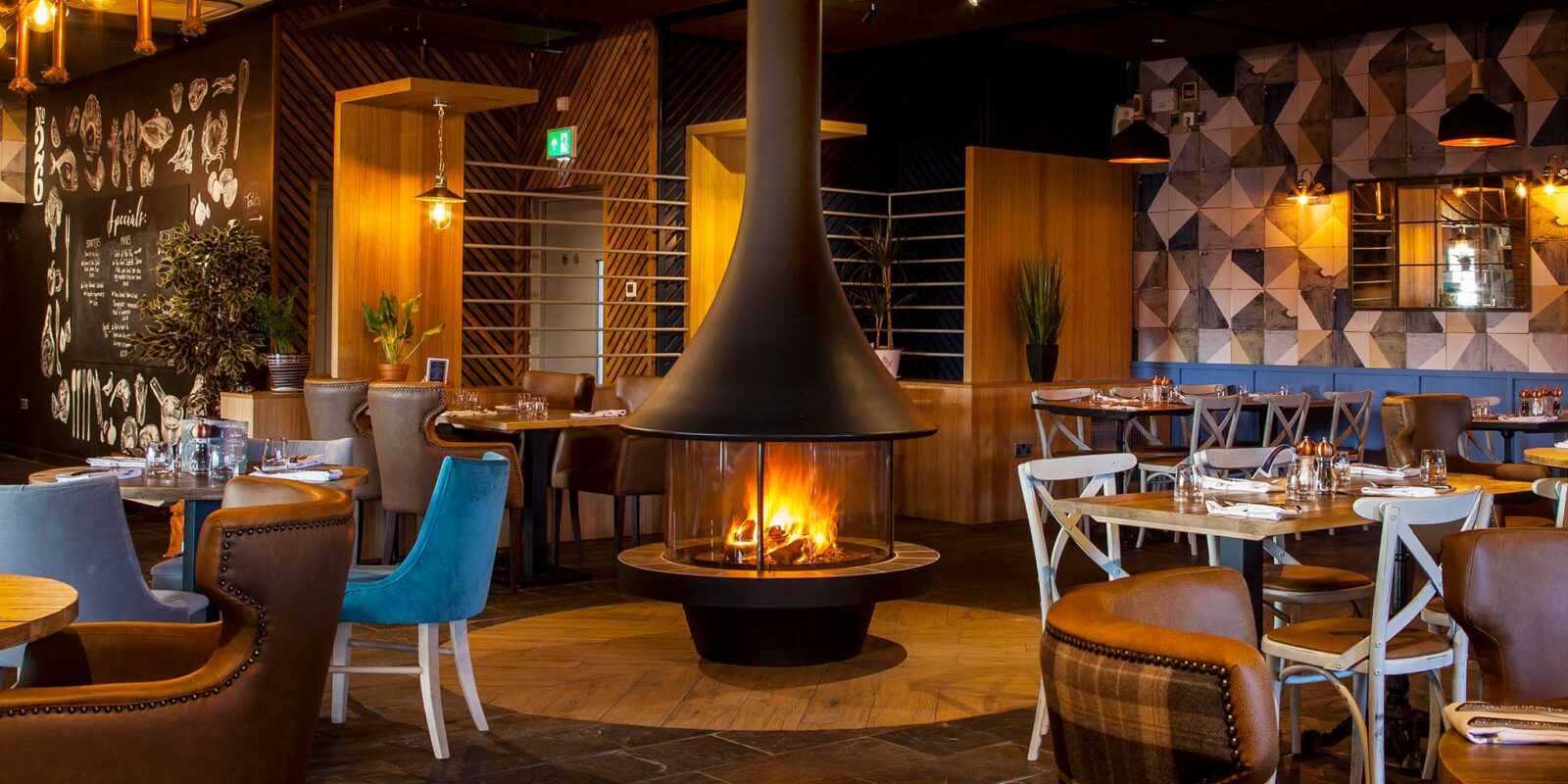 Black JC Bordelet Eva Luxury Suspended Fireplace in a warmly lite modern cafe.